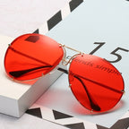 Sonnenbrille mit rotem Segmentglas und filigraner Metallfassung auf hellem Untergrund
