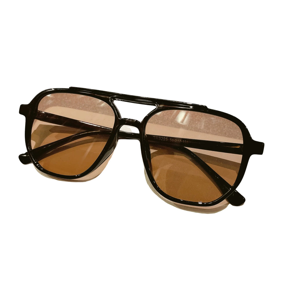 Braune Sonnenbrille mit schwarzem Rahmen – freigestellt auf weissem Hintergrund.