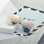 Verspiegelte Sonnenbrille mit zarten Pastelltönen auf ruhigem Untergrund
