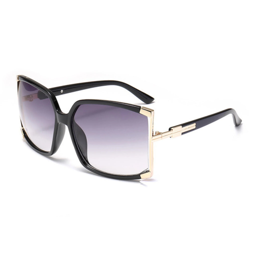 Sonnenbrille mit tiefschwarzem Rahmen, goldenen Eckdetails und grau getöntem Verlaufsglas – grossflächig, UV400