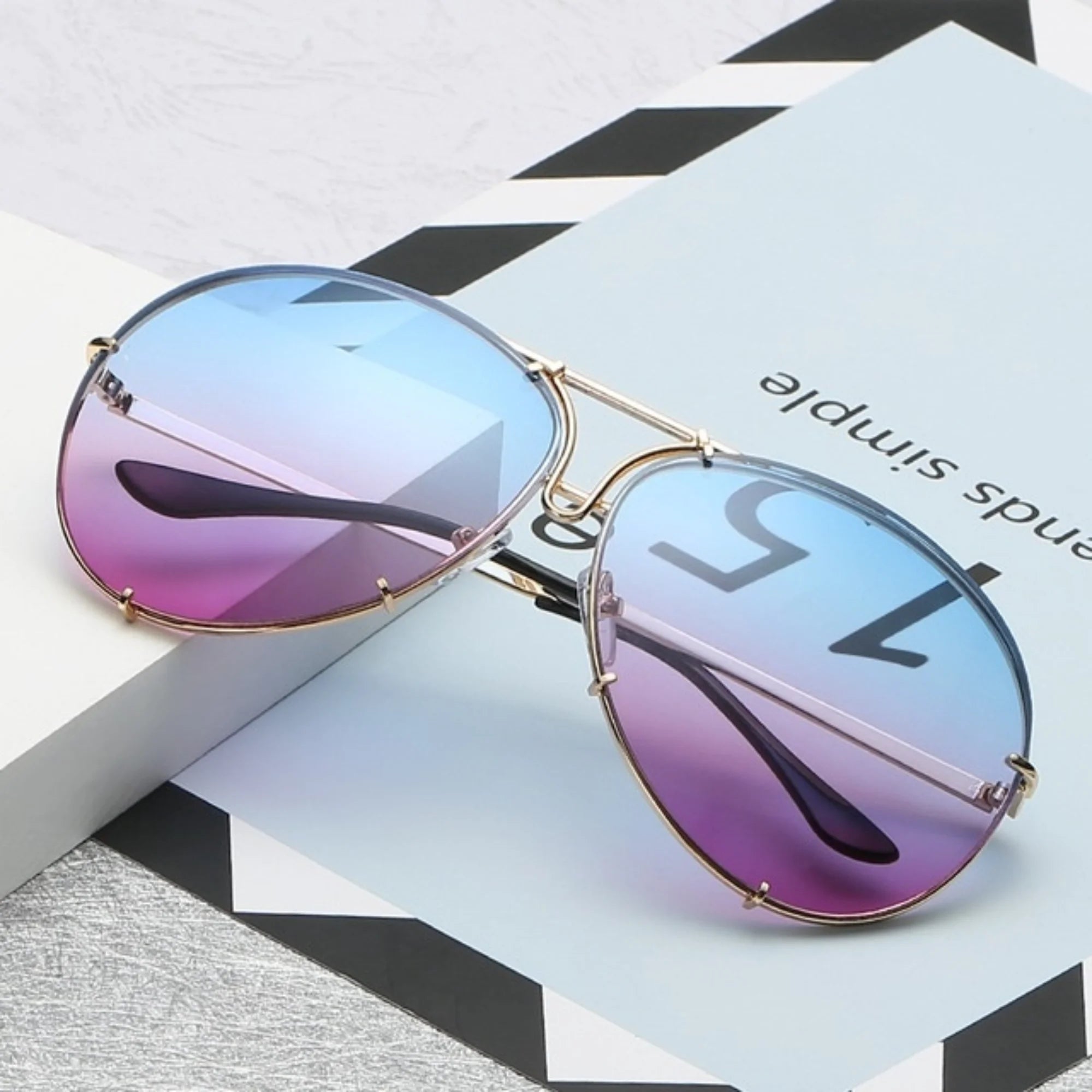 Brille mit blau-violettem Farbverlauf und ovalem Glas auf ruhigem Hintergrund