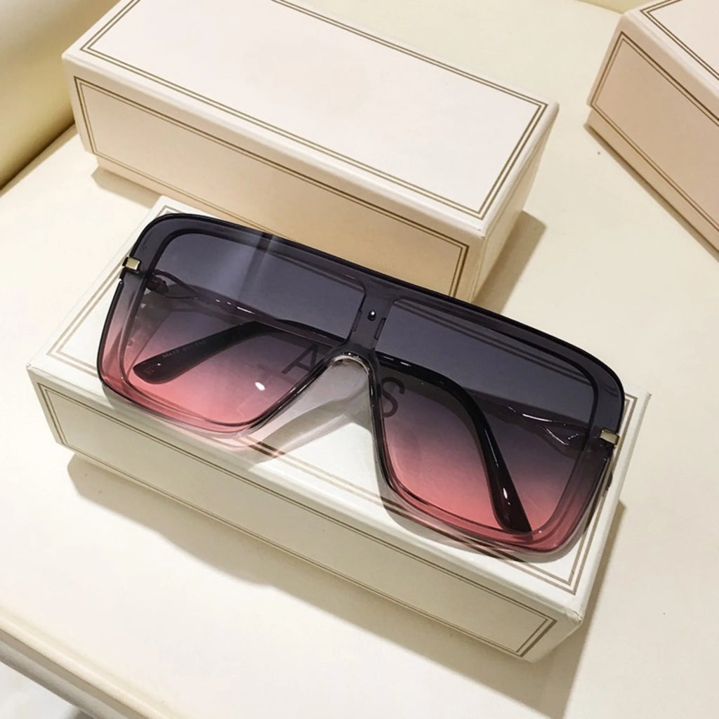 Segmentierte Visierbrille mit schwarzer Rahmenstruktur und rosa Tönung