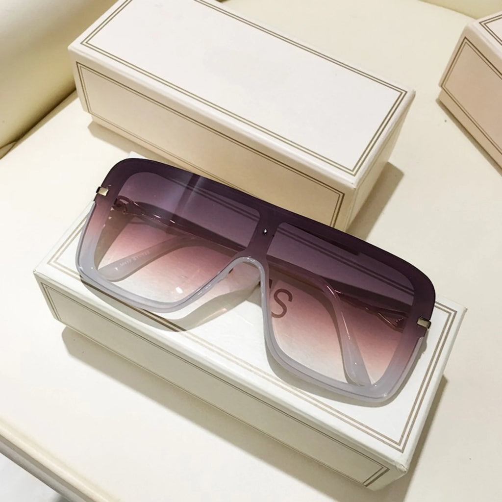 Rechteckige Sonnenbrille mit violett-weißem Verlaufsglas auf beiger Box