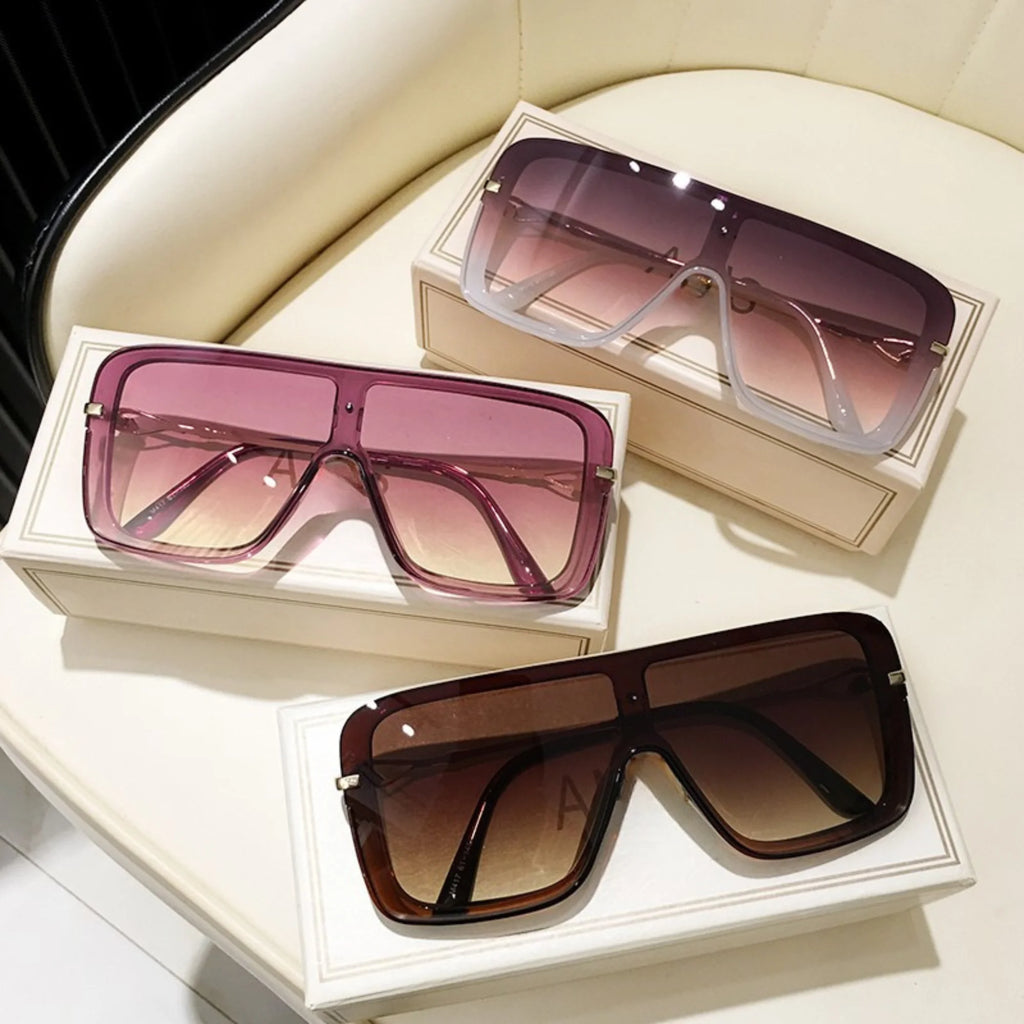 Drei visierartige Sonnenbrillen mit durchgehender Fläche in Braun, Rosa und Violett