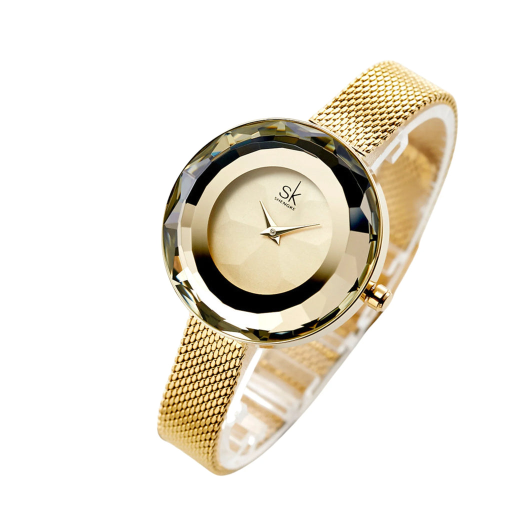 Uhr mit goldenem Meshband, kristallklarem Glasrahmen und zurückgenommenem Zifferblatt