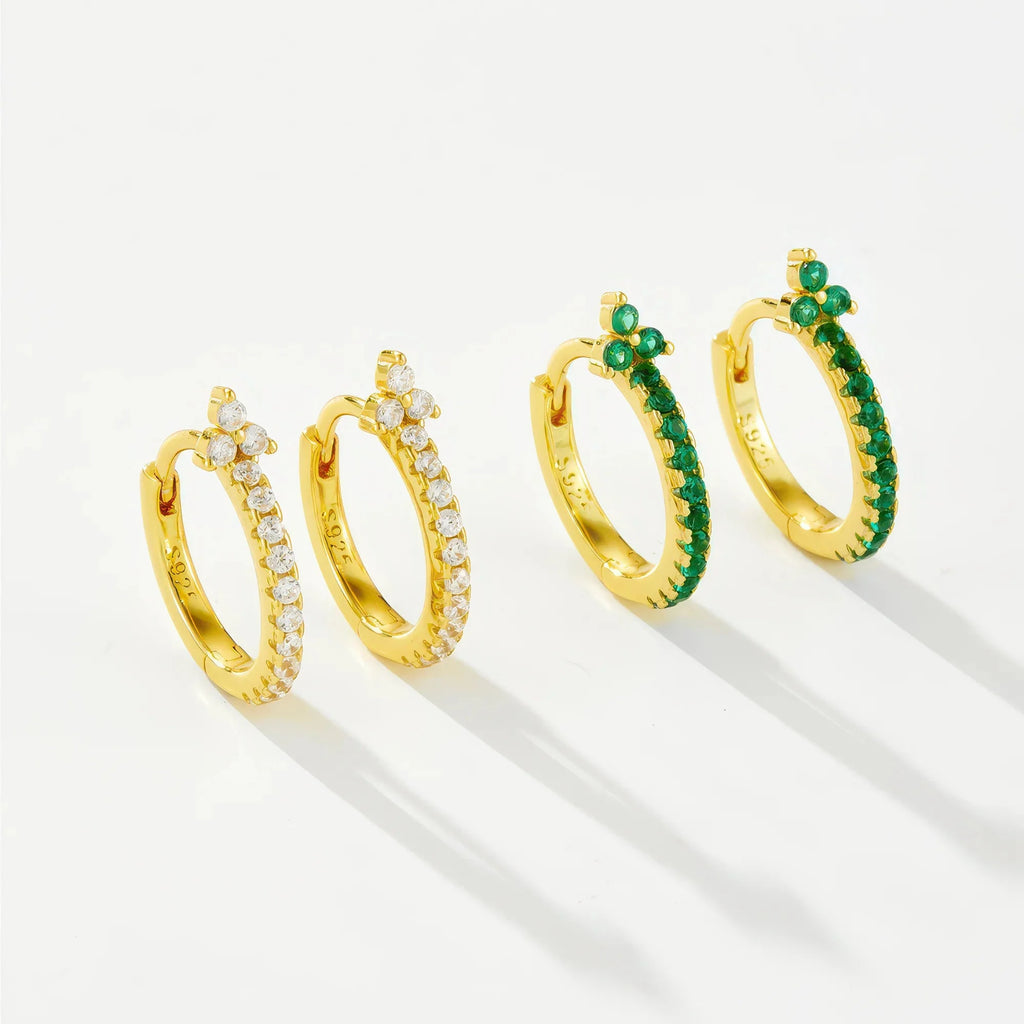 Zwei goldene Creolenpaare mit Zirkon – links klar, rechts smaragdgrün