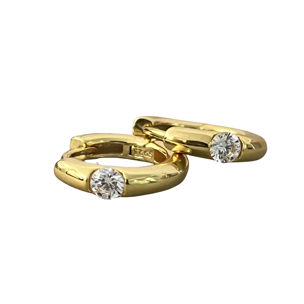 Goldfarbene Creolen mit mittigem Zirkonia, flach nebeneinander abgelegt